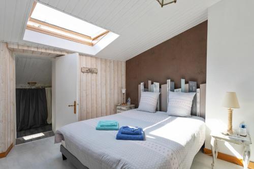 um quarto com uma grande cama branca e uma clarabóia em Au Clos de Launay Chambres d’Hôtes em Le Cellier