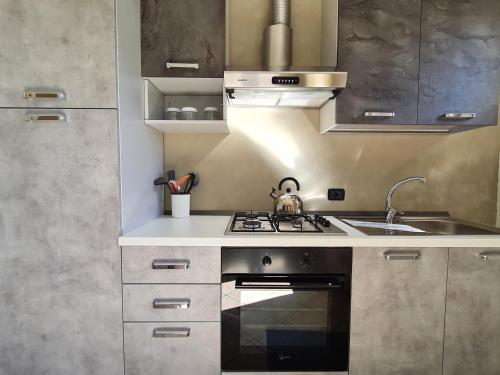 a kitchen with a stove and a sink at Appartamento Pederzoli in Peschiera del Garda