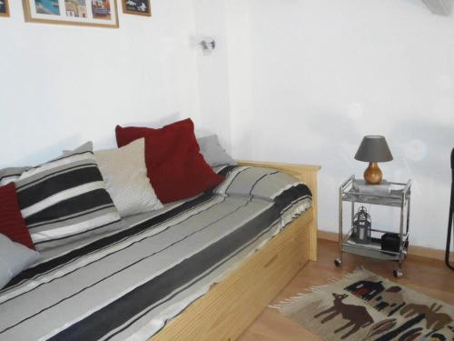 une chambre avec un lit avec des oreillers rouges et blancs dans l'établissement MAS DU SOLEIL Agréable villa mitoyenne 3 pièces Mt St Martin cap d'Agde, au Cap d'Agde