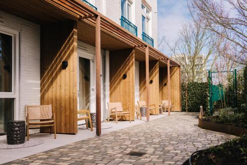 a patio with chairs and tables next to a building at Hotel Keur - Apartments in Zandvoort