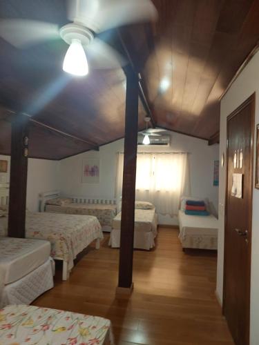 a room with four beds and a ceiling at Pousada Recanto da Fé in Cachoeira Paulista