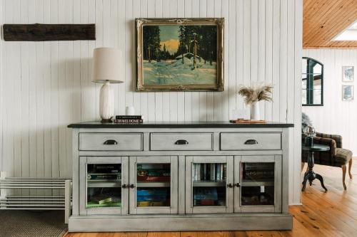 a white cabinet with glass doors in a living room at Alpine Lake House - Waterfront on Lake Muskoka in Port Carling
