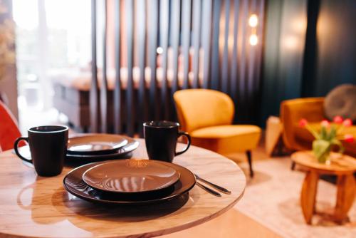 a table with two plates and two cups on it at Hotel Keur - Apartments in Zandvoort