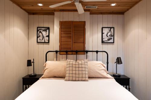 a bedroom with a bed with two lamps and a window at Alpine Lake House - Waterfront on Lake Muskoka in Port Carling