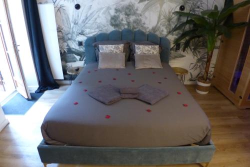 Una cama con cabecero azul y flores rojas. en Appartement balnéothérapie et sauna hyper centre, en Nantes