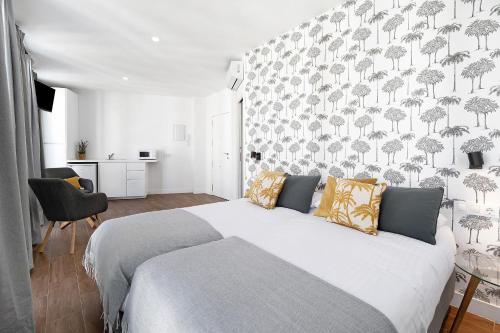 a bedroom with a large white bed with a patterned wall at Casa Milano 2 in Jerez de la Frontera