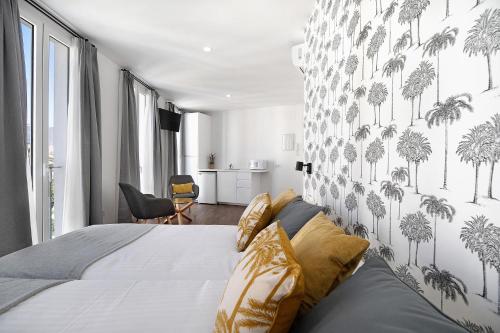 a bedroom with a bed and a wall with palm trees at Casa Milano 2 in Jerez de la Frontera