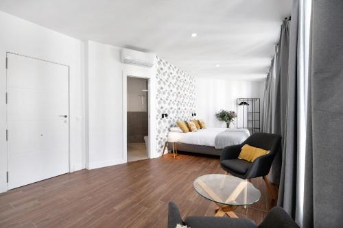 a bedroom with a bed and a chair and a table at Casa Milano 2 in Jerez de la Frontera