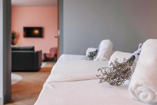 two beds with white sheets and flowers on them at Hotel Keur - Apartments in Zandvoort