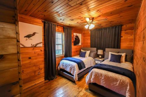 sypialnia z 2 łóżkami w drewnianym domku w obiekcie The Lodge at Mt. Hersey w mieście Hasty