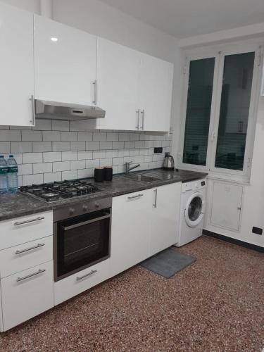 熱那亞的住宿－Il Faro alloggi turistici，白色的厨房配有炉灶和洗衣机。