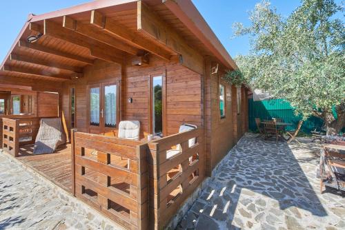 a wooden house with a porch and a patio at Montargil Lakeside Bliss, by TimeCooler in Montargil