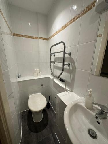 a white bathroom with a toilet and a sink at Berkeley Court Hotel in London