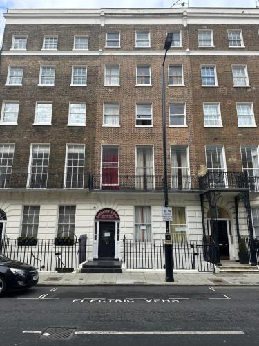 a large brick building with a red door on a street at Berkeley Court Hotel in London