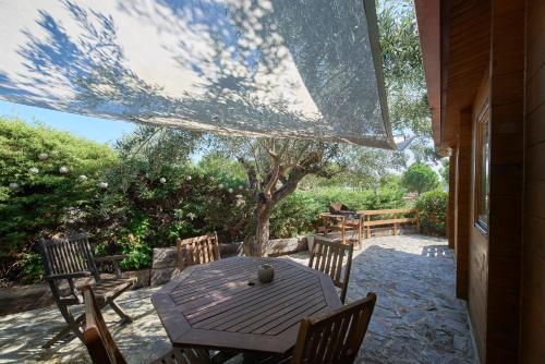 a wooden table and chairs on a patio at Montargil Lakeside Bliss, by TimeCooler in Montargil