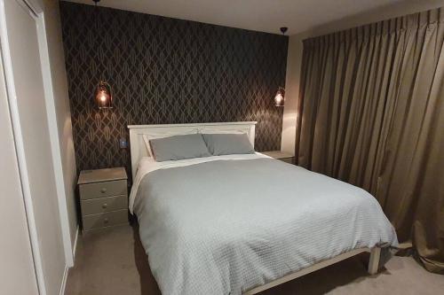 ein Schlafzimmer mit einem großen weißen Bett und zwei Leuchten in der Unterkunft Modern Two-Bedroom Home in Merivale in Christchurch