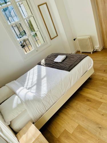 un grand lit dans une chambre avec une fenêtre dans l'établissement Le Léonard- T5 entre Loire et Château Royal - Manoir de la Concorde, à Amboise