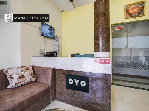 a lobby with a couch in front of a counter at Super OYO Kailash Park Near Shivaji International Airport in Mumbai