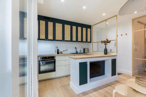 une cuisine avec des armoires blanches et un comptoir dans l'établissement La belle verrière-hyper centre, à Mont-de-Marsan