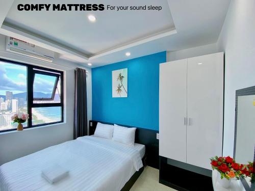 une chambre avec un lit et un mur bleu dans l'établissement Căn hộ 2 phòng ngủ view biển Mỹ Khê Đà Nẵng, à Đà Nẵng