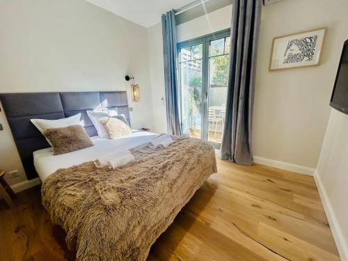 une chambre avec un grand lit et une grande fenêtre dans l'établissement Apt 2-4pers/6'piedplage/terrasse/parking, à Arcachon