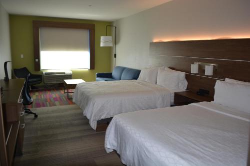 una camera d'albergo con due letti e una sedia di Holiday Inn Express & Suites a Liberal
