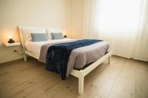 Un dormitorio con una cama con una manta azul. en Casas do Navalhão, en São Roque do Pico