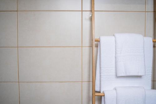 - un porte-serviettes dans une salle de bains revêtue de carrelage blanc dans l'établissement Casas do Navalhão, à São Roque do Pico