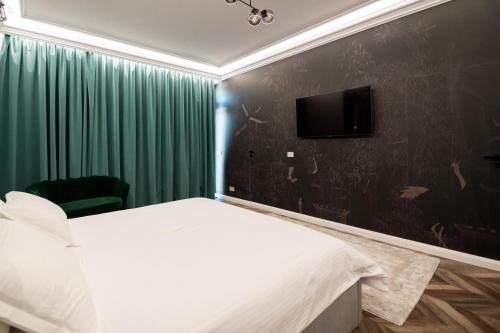 - une chambre avec un lit et une télévision murale dans l'établissement The Penthouse, à Vaslui