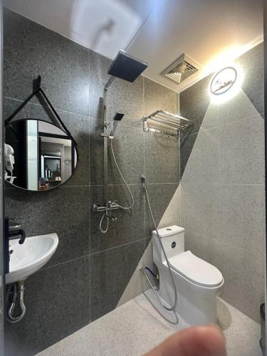 a bathroom with a toilet and a sink and a mirror at Hồng Vân Homestay in Cao Bằng