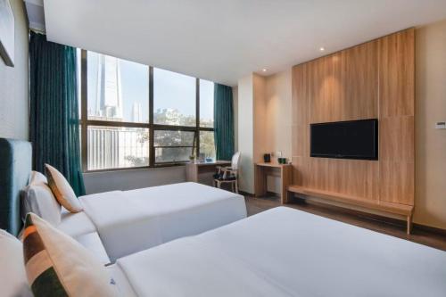 a hotel room with two beds and a flat screen tv at Platinum Times Aparthotel in Shenzhen