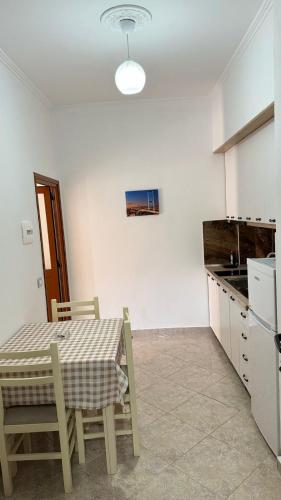 a kitchen with a table and a table and chairs at Amel's Apartments Comfortable Family Stay Near Orikum Beach in Orikum