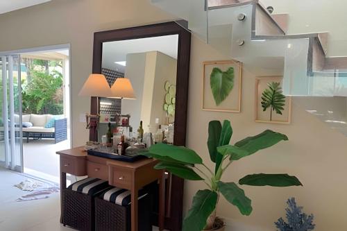 ein Badezimmer mit einem Spiegel und einer Pflanze an der Wand in der Unterkunft Beira mar alto padrão! in Bertioga