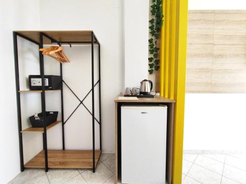 a room with a shelf and a white refrigerator at Nemesis in Fira