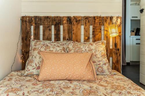a bed with a wooden headboard and two pillows at L'Écrin Vue Mer in Saint-Paul