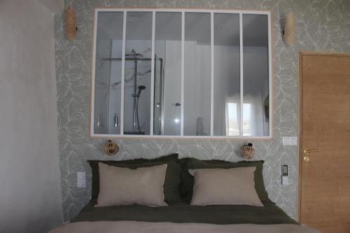 ein Schlafzimmer mit einem Spiegel über einem Bett in der Unterkunft Domaine de KIBA - Maison de Maitre in Barzan