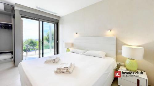 ein weißes Schlafzimmer mit einem großen weißen Bett und einem Fenster in der Unterkunft Villa Shiera by Bravos Club in Finestrat