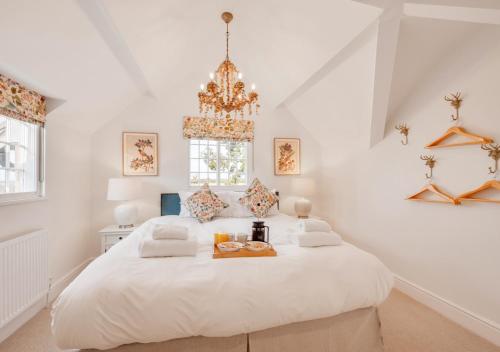ein weißes Schlafzimmer mit einem großen weißen Bett und einem Tablett darauf in der Unterkunft Cuckoo Lodge in Wighton