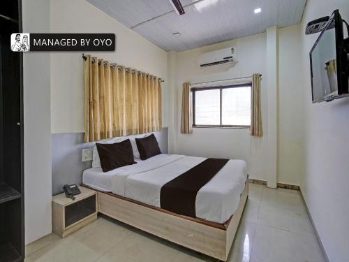 a bedroom with a bed and a television in it at Super OYO Kailash Park Near Shivaji International Airport in Mumbai
