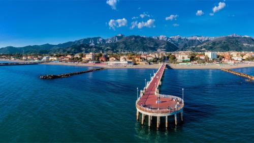 a pier in the water next to a beach at Casa Massa in Massa