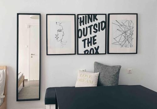 a room with four framed pictures on a wall at City Center Studio Apartment in Heraklio