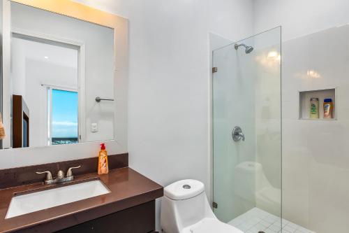 a bathroom with a shower and a sink and a toilet at Casa Marfil 26 - Playa Arcangel in Rosarito