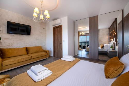 a living room with a couch and a tv at Geroulios Kastro, a Grand Estate, By ThinkVilla in Vatoudhiáris