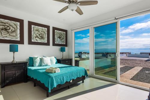 a bedroom with a bed and a large window at Casa Aquamarina 43 - Playa Arcangel in Rosarito