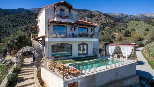 a house with a swimming pool on a mountain at Geroulios Kastro, a Grand Estate, By ThinkVilla in Vatoudhiáris