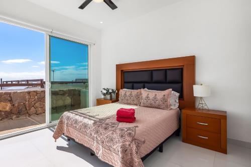 a bedroom with a bed with a red bag on it at Casa Roble 24 - Playa Arcangel in Rosarito