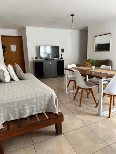 1 dormitorio con cama, mesa y comedor en Dpto Paraná - Piscina, calefacción y aire acond en Córdoba