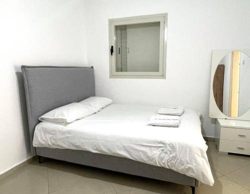 - une chambre avec un lit avec un miroir et une fenêtre dans l'établissement TRENDY 2BR GOLF RESIDENCE EILAT, à Eilat