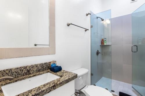 uma casa de banho com um WC e uma cabina de duche em vidro. em Jr Suite 1 - Playa Arcangel em Rosarito