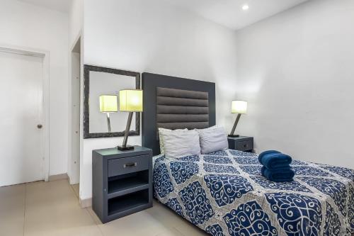 um quarto com uma cama azul e branca com 2 candeeiros em Jr Suite 1 - Playa Arcangel em Rosarito